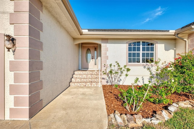 doorway to property featuring stucco siding