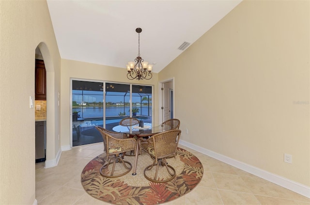 dining room with a chandelier, light tile patterned floors, visible vents, baseboards, and vaulted ceiling