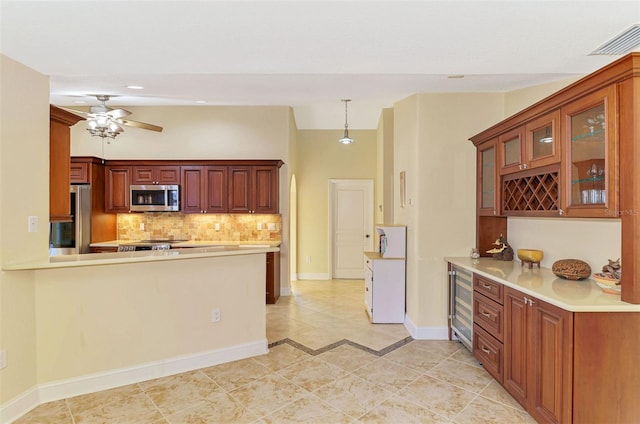 kitchen with stainless steel appliances, light countertops, visible vents, and backsplash