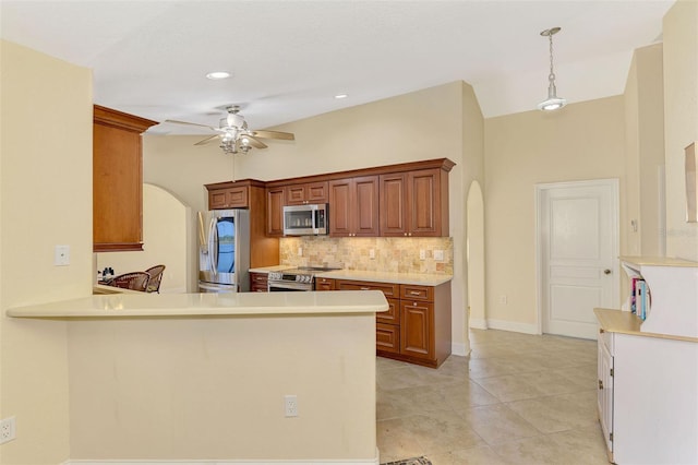 kitchen with stainless steel appliances, arched walkways, light countertops, and backsplash