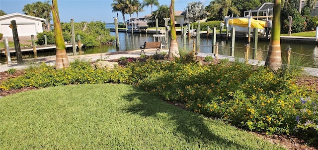 view of yard with a water view and a dock