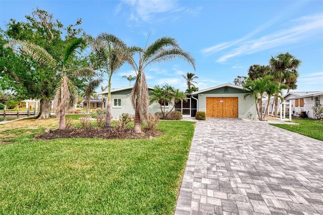 ranch-style home featuring stucco siding, decorative driveway, and a front yard