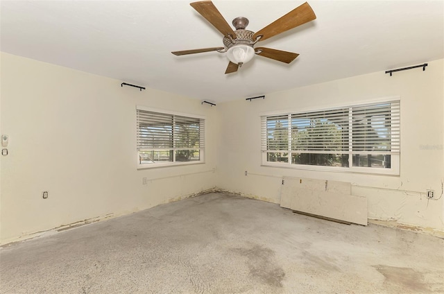 empty room with a ceiling fan and a wealth of natural light