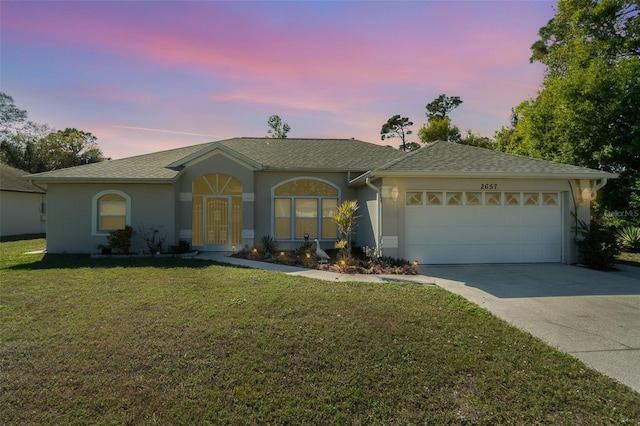 ranch-style home with a yard and a garage