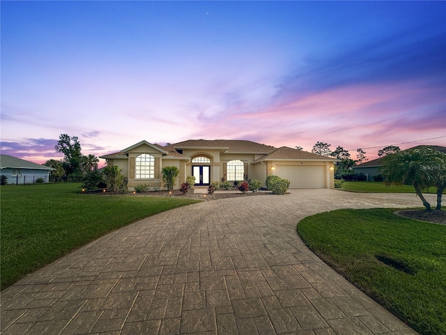 view of front of house featuring a garage and a yard