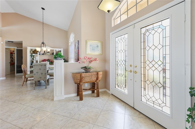 entryway featuring light tile patterned flooring, high vaulted ceiling, a chandelier, and french doors