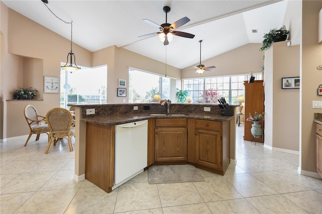 kitchen featuring vaulted ceiling, sink, dark stone countertops, light tile patterned floors, and white dishwasher