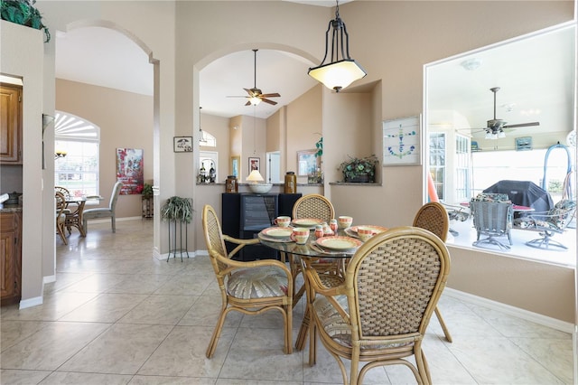 dining area featuring light tile patterned floors, high vaulted ceiling, and ceiling fan