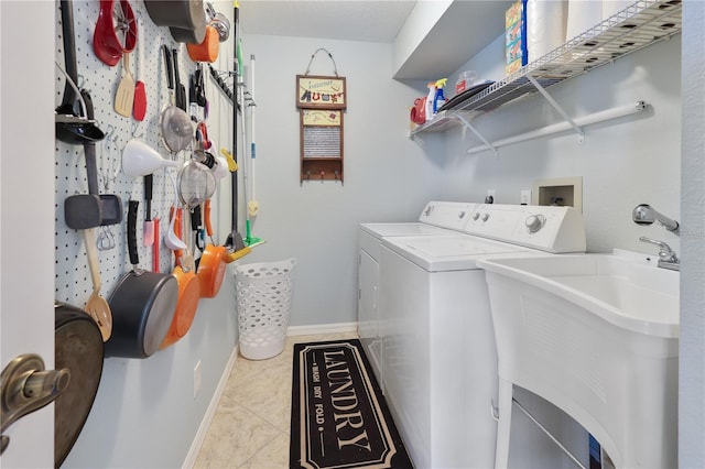 laundry area with sink, light tile patterned floors, and washing machine and clothes dryer