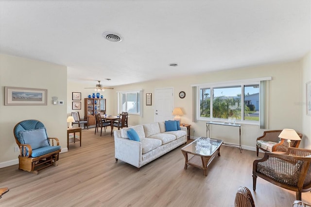 living room with ceiling fan, a healthy amount of sunlight, and light wood-type flooring