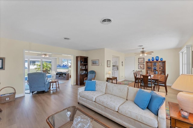 living room with wood-type flooring and ceiling fan