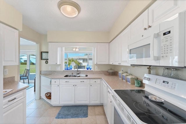 kitchen with white cabinetry, sink, white appliances, and light tile patterned floors