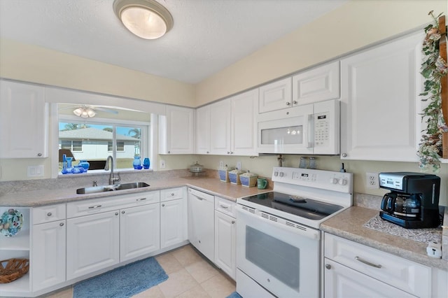 kitchen featuring sink, white appliances, white cabinetry, a textured ceiling, and light tile patterned flooring