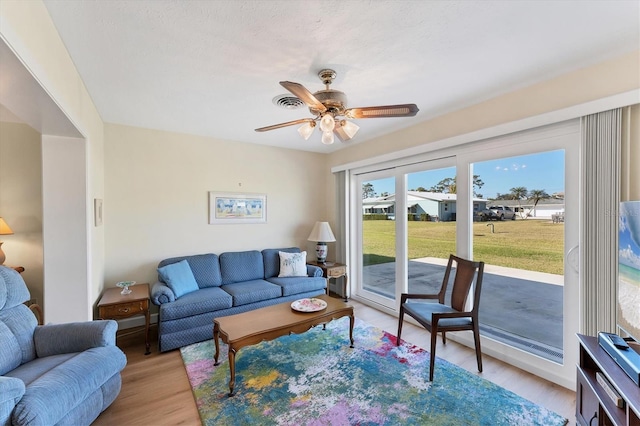 living room with ceiling fan and light hardwood / wood-style floors