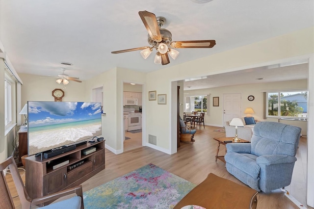 living room with ceiling fan and light hardwood / wood-style floors