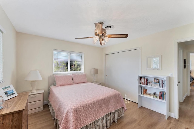 bedroom featuring ceiling fan, a closet, and light hardwood / wood-style flooring