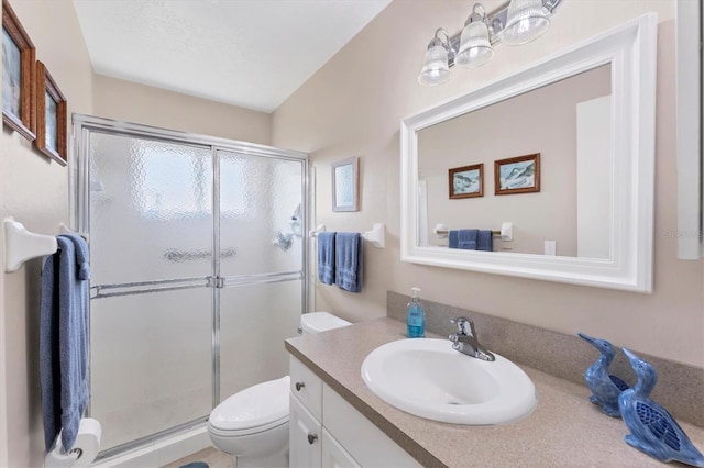 bathroom featuring vanity, toilet, and a shower with shower door