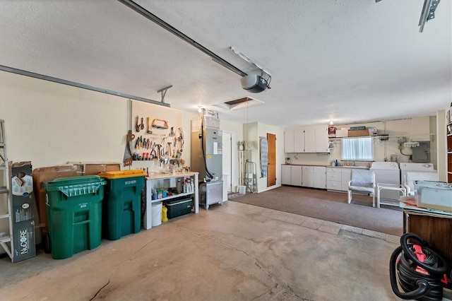 garage with a garage door opener, a workshop area, and washer and dryer