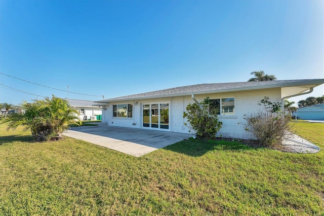 rear view of property featuring a lawn and a patio area