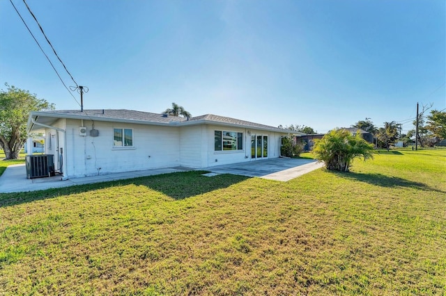 back of property with a patio, a lawn, and central air condition unit