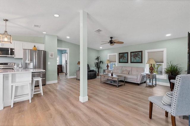 living room with ceiling fan, lofted ceiling, and light hardwood / wood-style floors