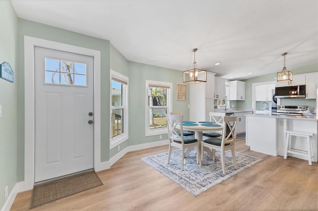 dining area featuring sink and light wood-type flooring