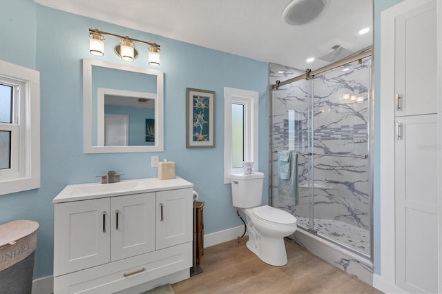 bathroom featuring vanity, toilet, a shower with shower door, and hardwood / wood-style floors