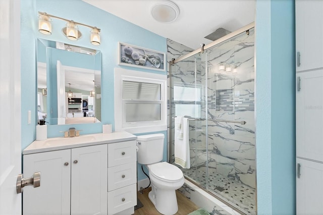 bathroom with vanity, toilet, a shower with shower door, and wood-type flooring