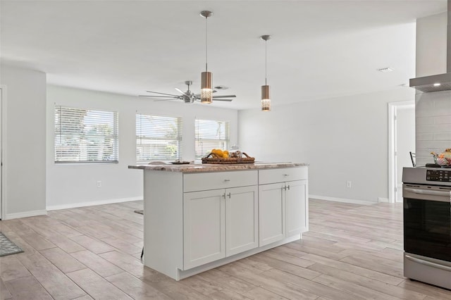 kitchen with wall chimney exhaust hood, white cabinets, light hardwood / wood-style floors, and electric stove