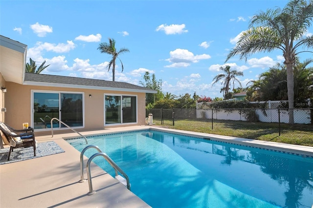 view of swimming pool featuring a patio and a yard