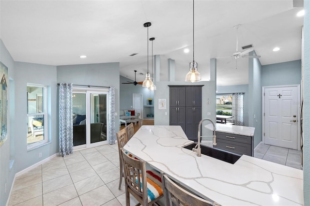 kitchen featuring pendant lighting, sink, ceiling fan, light stone countertops, and vaulted ceiling