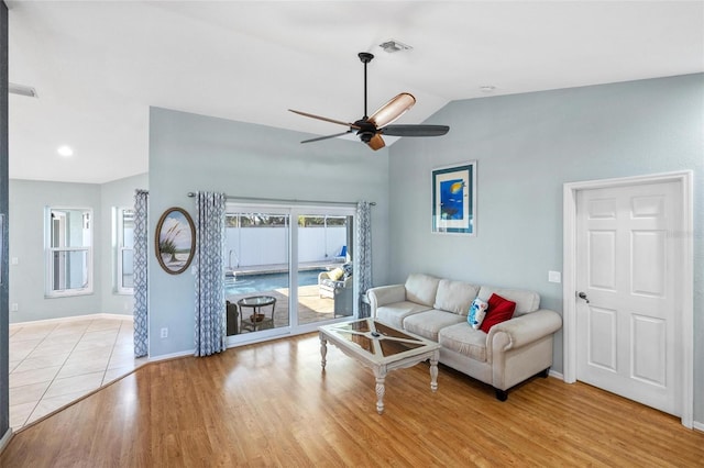 living room featuring ceiling fan, lofted ceiling, and light hardwood / wood-style floors