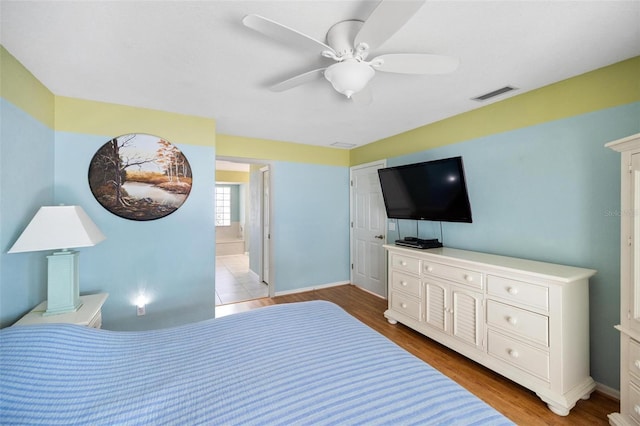 bedroom featuring ceiling fan, connected bathroom, and light hardwood / wood-style floors