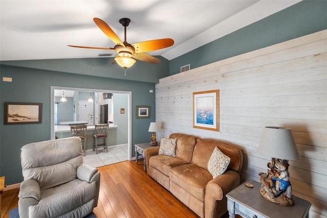 living room with vaulted ceiling, light hardwood / wood-style floors, and ceiling fan