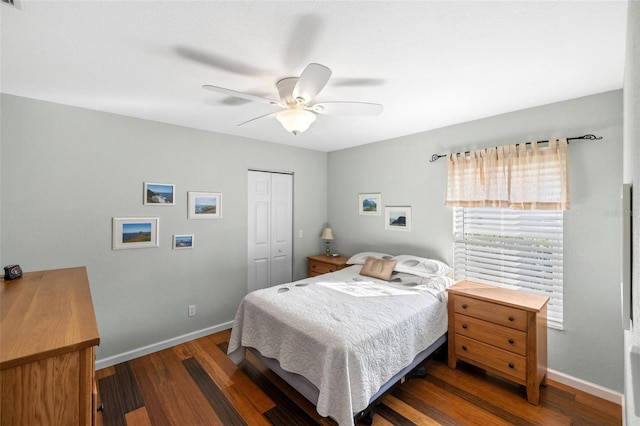 bedroom with dark wood-type flooring, ceiling fan, and a closet