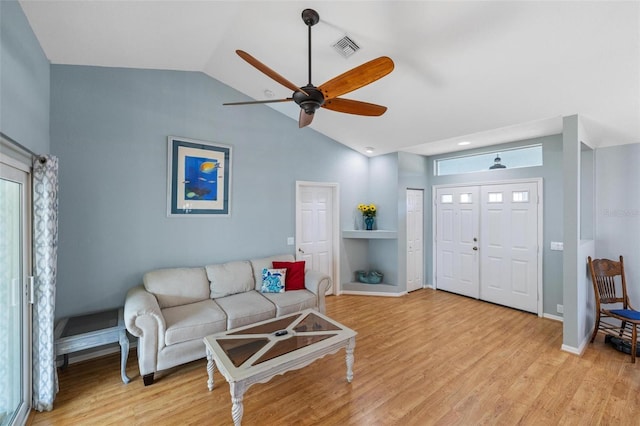 living room featuring ceiling fan, lofted ceiling, and light hardwood / wood-style flooring