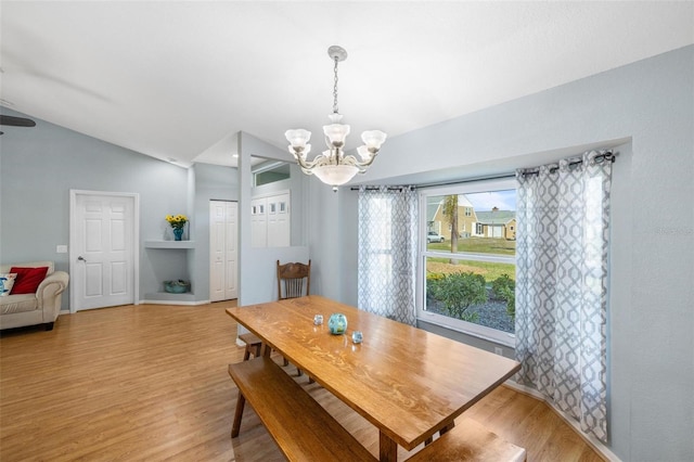 dining room featuring lofted ceiling, a chandelier, and light hardwood / wood-style flooring