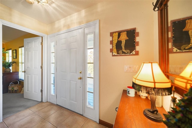 foyer entrance featuring light tile patterned flooring and a healthy amount of sunlight