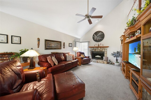 carpeted living room with ceiling fan, a stone fireplace, and high vaulted ceiling