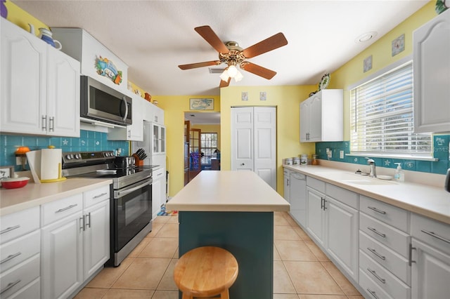 kitchen featuring appliances with stainless steel finishes, a center island, and white cabinets