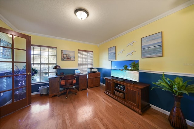 office area featuring a textured ceiling, wood-type flooring, ornamental molding, and a healthy amount of sunlight