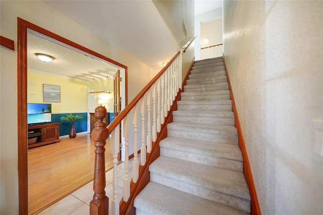 stairway featuring tile patterned floors and a textured ceiling