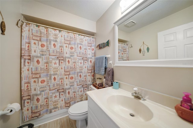 bathroom featuring vanity, hardwood / wood-style floors, a textured ceiling, and toilet