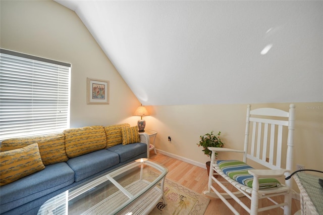 living room featuring wood-type flooring and vaulted ceiling