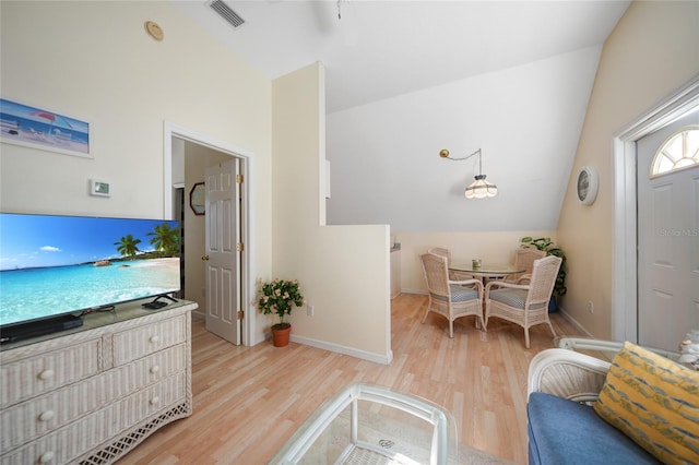 living room featuring lofted ceiling and light hardwood / wood-style flooring