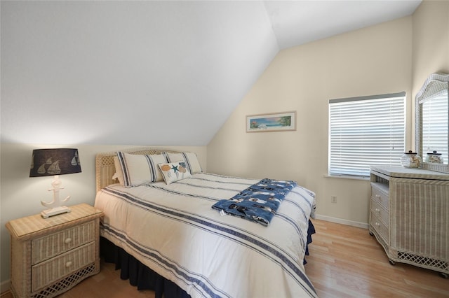 bedroom featuring lofted ceiling and light wood-type flooring