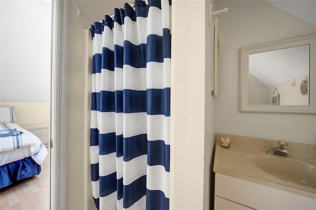 bathroom featuring vanity, curtained shower, and vaulted ceiling