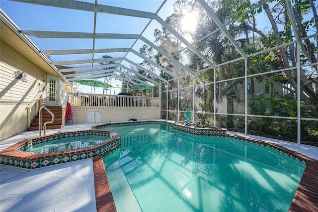 view of pool featuring an in ground hot tub and glass enclosure