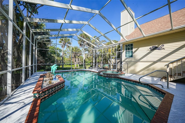 view of pool with an in ground hot tub, a patio area, and glass enclosure