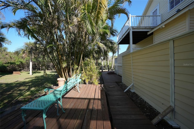 wooden terrace featuring a lawn